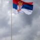 Serbian flag majestically waving against an overcast sky, showcasing national pride.