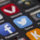 A detailed close-up of social media icons on a smartphone screen, including Facebook and Twitter.