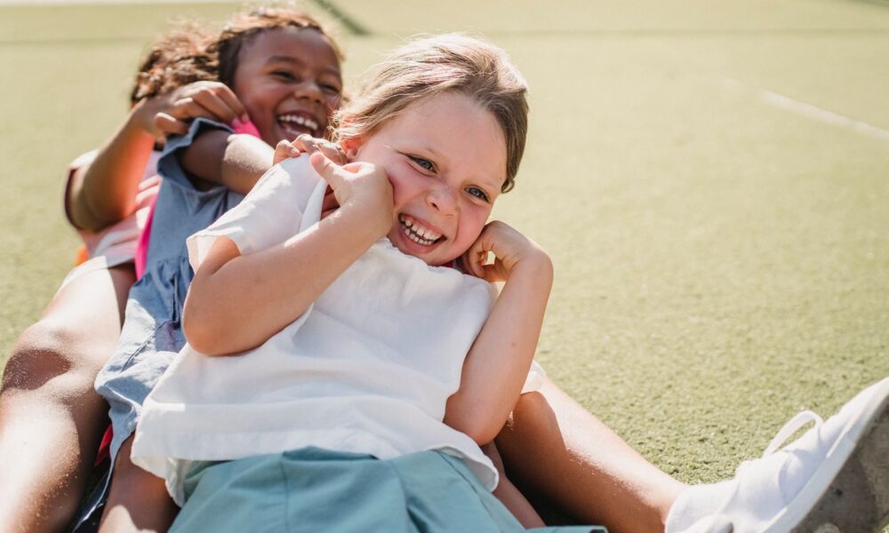 Joyful children smiling and playing on a sunny day outdoors.
