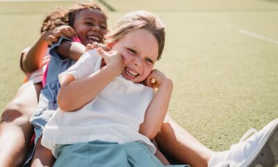 Joyful children smiling and playing on a sunny day outdoors.