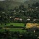 A picturesque village nestled among verdant hills and dense forests, showcasing rural beauty.
