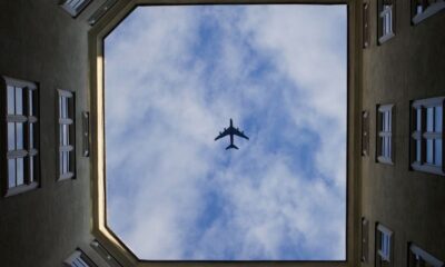 A unique view of an airplane flying above a courtyard in Vienna, Austria.