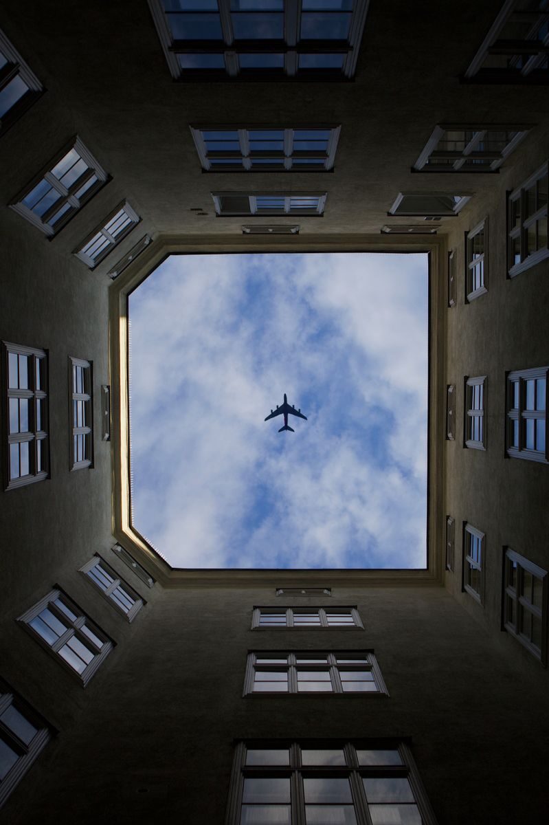 A unique view of an airplane flying above a courtyard in Vienna, Austria.
