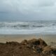 A dynamic view of the ocean with waves crashing against a rocky shore under a cloudy sky, ideal for dramatic landscapes.