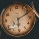 Captivating close-up of a vintage analog clock showcasing historical charm and intricate details.