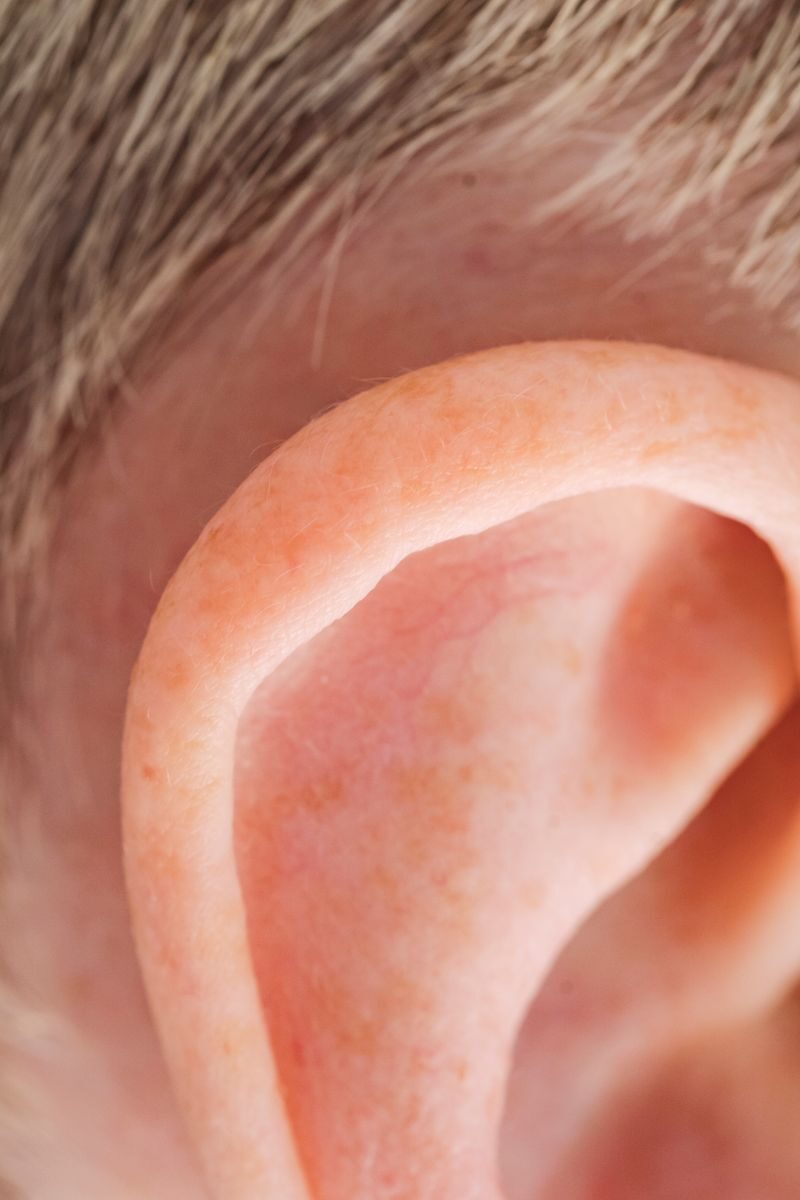 Detailed close-up photo of a human ear showcasing skin texture and hair.
