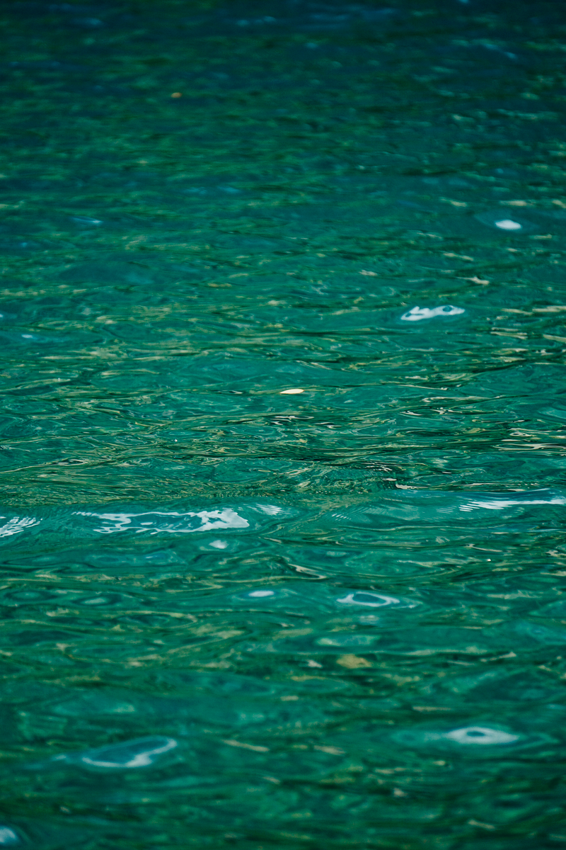 Calm emerald water surface with gentle ripples creating a soothing texture