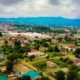 Drone shot of a vibrant townscape in Mbeya, Tanzania, surrounded by greenery and hills.