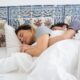 A couple peacefully sleeping together hugged in a cozy bed with colorful tiles.
