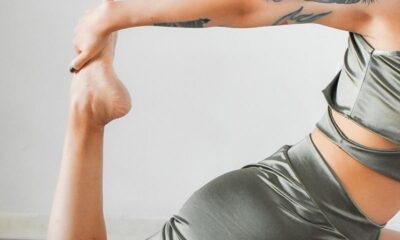 Female athlete in sportswear practicing a stretching pose on a yoga mat.