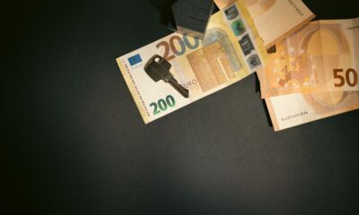 Flat lay of a house key on Euro bills representing real estate investment and finance.