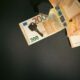 Flat lay of a house key on Euro bills representing real estate investment and finance.