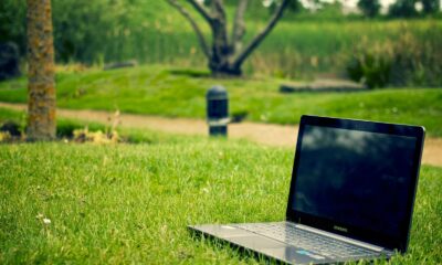 Laptop placed on green grass in a park setting, ideal for remote work and digital nomad lifestyle.