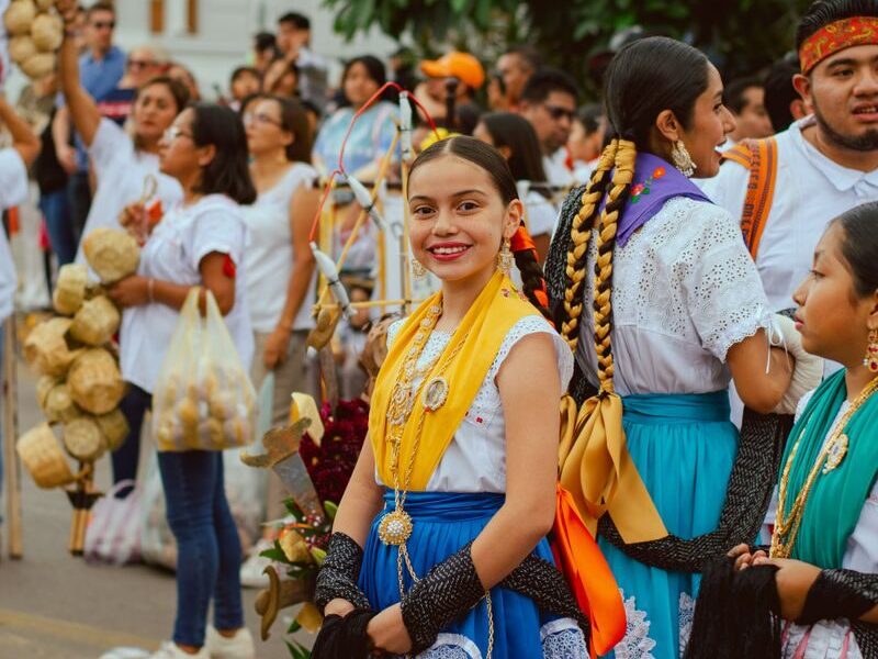 Colorful celebration in Oaxaca, showcasing traditional clothing and joyful participants.