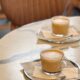 Two frothy cappuccinos on a marble cafe table, set for a cozy coffee break.