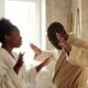 A couple in bathrobes having an emotional discussion in an indoor setting with expressive hand gestures.