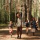 A family enjoys a day of hiking and exploring in a dense forest, promoting outdoor fun and bonding.