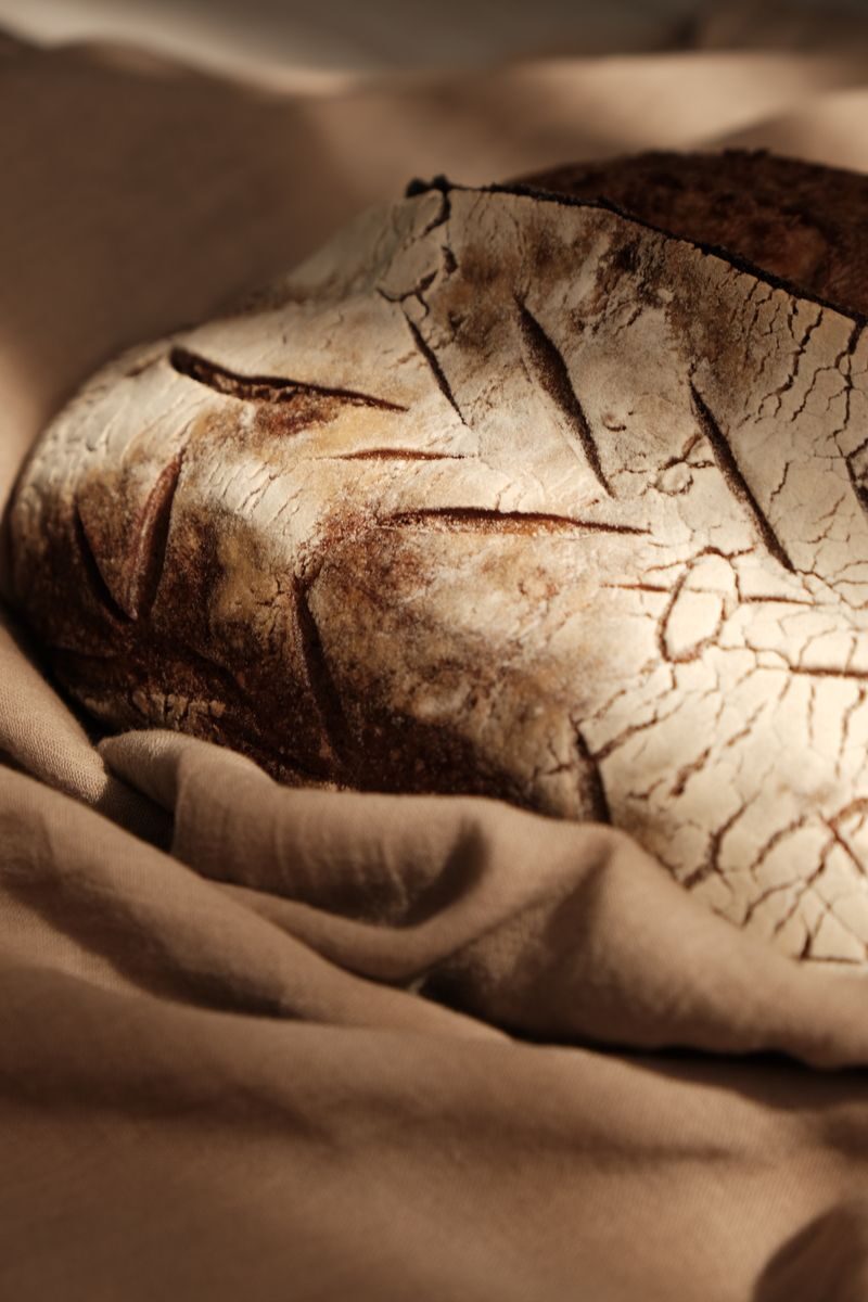 Close-up of artisan bread showcasing its rustic crust, resting on a fabric.