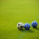Three soccer balls positioned on a vibrant green field in the afternoon sun, perfect for sports themes.