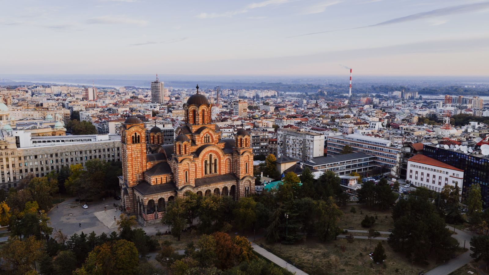 Captivating aerial view of Belgrade cityscape with St. Mark's Church at sunset.