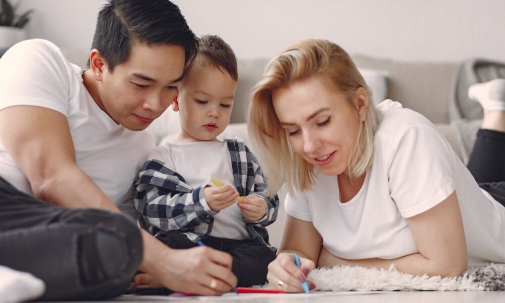 A family enjoys a fun and creative bonding session with drawing activities indoors.