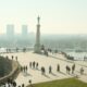 Scenic view from Belgrade Fortress overlooking the city and river, people walking in the plaza.