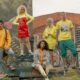 Fashionable group posing in vibrant street style against graffiti mural backdrop.