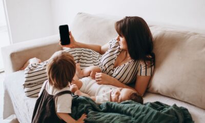 A mother and her children enjoy leisure time on the sofa, highlighting family togetherness and relaxation.