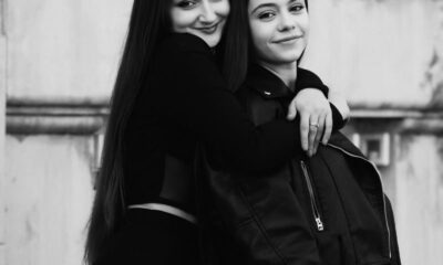 Charming black and white portrait of two young women embracing and smiling, showcasing friendship.