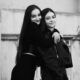 Charming black and white portrait of two young women embracing and smiling, showcasing friendship.
