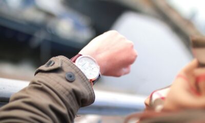 A person checks their wristwatch in a hurried outdoor setting, emphasizing time management.