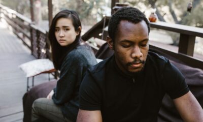 A couple in a serious moment, suggesting conflict or breakup, outdoors.