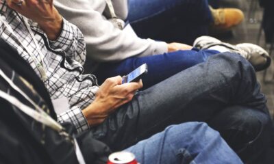 People sitting at a conference casually checking smartphones, communicating and networking.