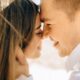 Close-up of a smiling couple sharing a romantic moment outdoors in daylight.