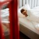 A woman enjoys a restful sleep on a comfortable bed in a tranquil bedroom setting.