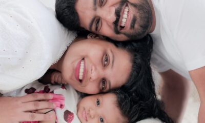 Happy family portrait with parents and baby, showcasing love and togetherness indoors.