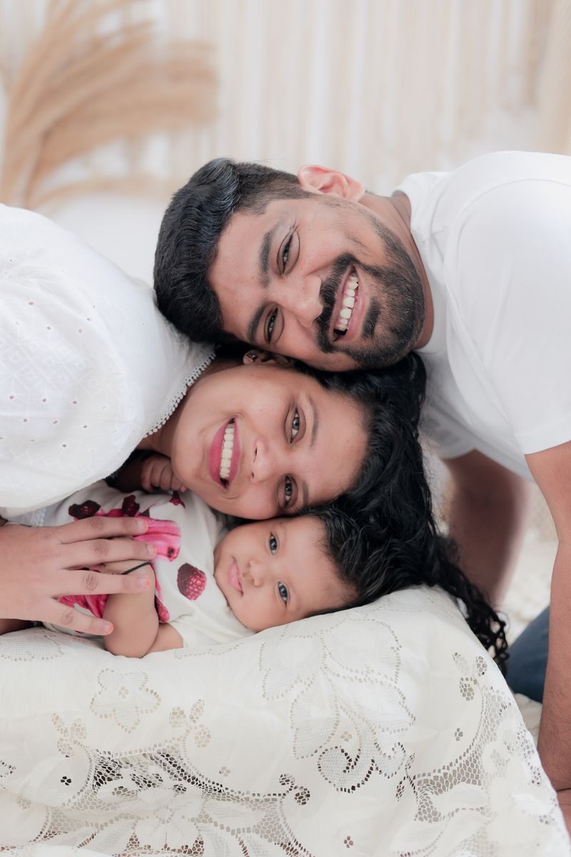 Happy family portrait with parents and baby, showcasing love and togetherness indoors.
