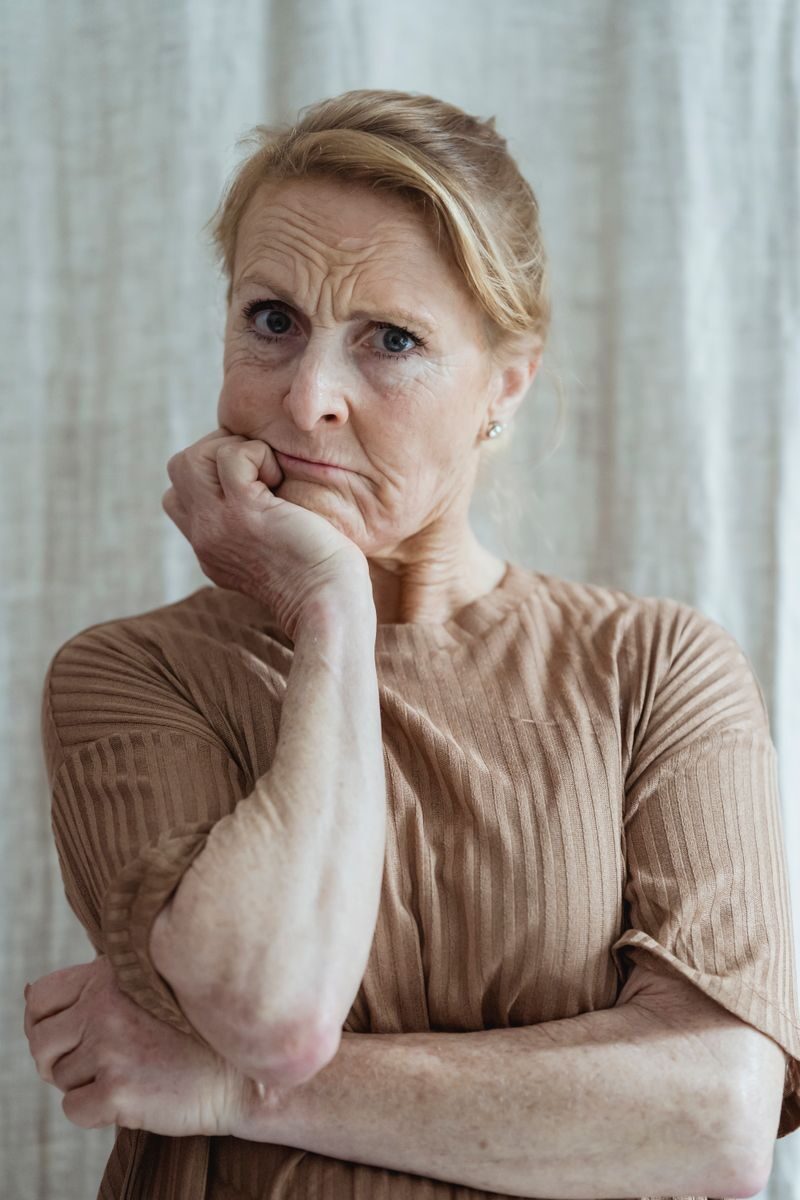 Portrait of a serious senior woman in a thoughtful pose indoors.