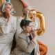A joyful celebration with senior women in party hats blowing party blowers indoors.