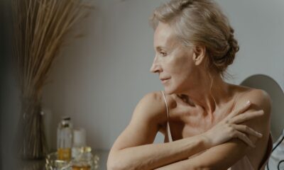 A serene and elegant portrait of a mature woman in a relaxed pose indoors, showcasing natural beauty.