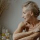 A serene and elegant portrait of a mature woman in a relaxed pose indoors, showcasing natural beauty.