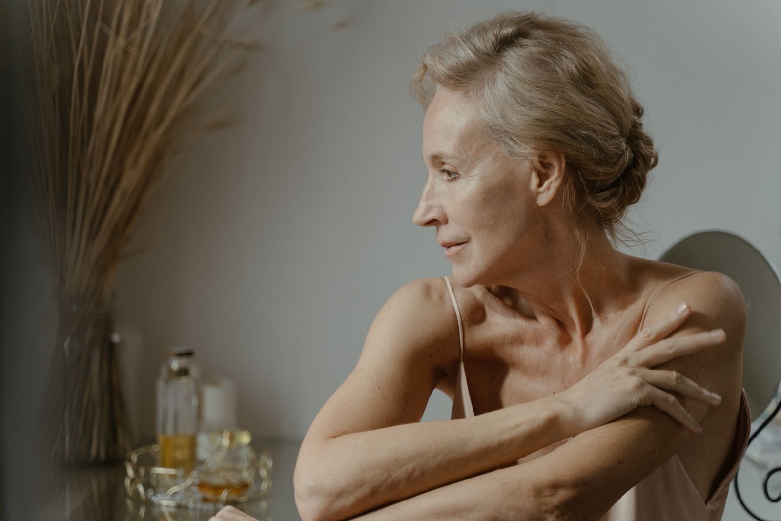 A serene and elegant portrait of a mature woman in a relaxed pose indoors, showcasing natural beauty.