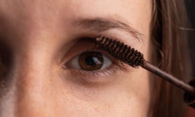 Detailed close-up of an eye with mascara being applied for beauty enhancement.