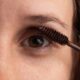 Detailed close-up of an eye with mascara being applied for beauty enhancement.