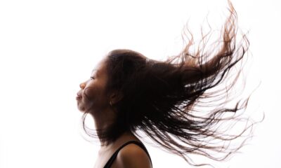 A high-contrast profile of a woman with her hair flowing, showcasing movement and expression.