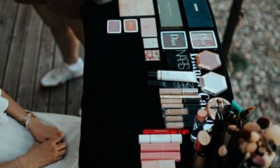 Top view of various makeup products on a table outdoors in Muğla, Türkiye.