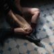An artistic shot of a woman sitting on a vintage patterned tiled floor, showcasing fashion and style.