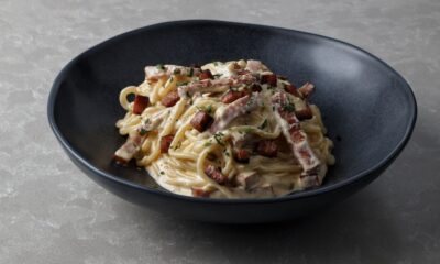 Mouth-watering spaghetti carbonara with creamy sauce and crispy bacon bits served in a bowl.