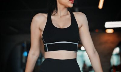 Woman in athletic wear exercising in a gym with contemporary lighting.