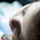 Intimate close-up photo of a child's face in soft light, focusing on serene eyelashes.